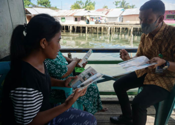 Petugas dari BPJS Kesehatan Boalemo tengah memberikan sosialisasi JKN Mobile bagi warga pesisir di Desa Bajo, Kecamatan Tilamuta. (Foto: Lukman Polimengo/mimoza.tv)