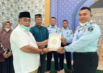 Pembina Komunitas Pecinta Al Quran (KOTAQU) Kota Gorontalo, Adhan Dambea menyerahkan bantuan Al Quran kepada Kepala LPKA Kelas II Gorontalo,  Kurnia Panji Pamakasan, Kamis (21/7/2022). Foto : Dokumentasi KOTAQU.