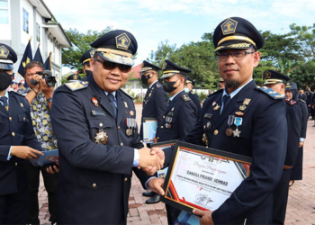 epala Kanwil Kemenkumham Gorontalo, Heni Susila Wardoyo, menyerahkan piagam penghargaan kepada pegawai berprestasi, dalam upacara Peringatan Hari Hari Dharma Karya Dhika Ke-77, yang digelar di lapangan Upacara Kanwil Kemenkumham Provinsi Gorontalo, Jumat (19/8/2022).