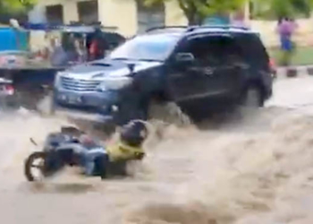 Seorang pemotor yang mencoba menerobos air malah nyaris hanyut, tidak kuat menerjang arus deras banjiryang terjadi di Desa Labanu, Kecamatan Tibawa, Kabupaten Gorontalo. Foto : tangkapan layar