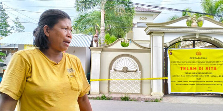 Anita Lamusu saat diwawancarai awak media di depan rumah milik FA dan SHM, di Kelurahan  pasutri yang diduga melakukan tindak pidana pencucian uang di UD Tiga Sejati. Foto : Lukman Polimengo/mimoza.tv.
