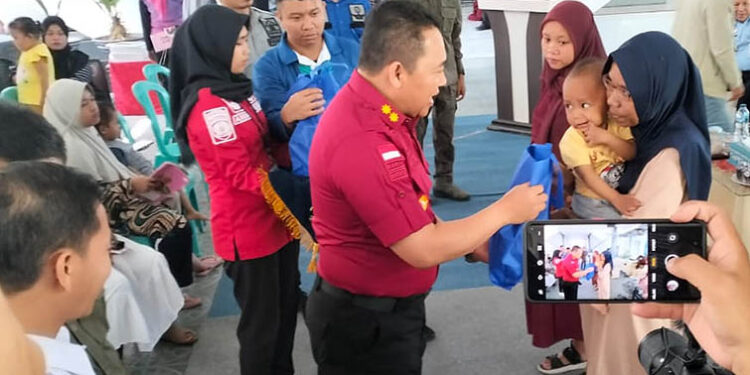 Kepala Kantor Wilayah Kemenkumham Gorontalo, Heni Susila Wardoyo (kemeja merah) saat memberikan bingkisan pada kegiatan Bakti Sosial Kanwil Kemenkumham Gorontalo Cegah Stunting, Sabtu (29/7/2023). Foto : Lukman Polimengo/mimoza.tv.