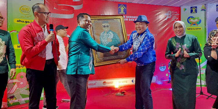 Kepala Lembaga Pemasyarakatan Kelas IIb Pohuwato, Irman Jaya (baju batik hijau), menyerahkan lukisan hasil karya dari narapidana kepada Kakanwil Kementerian Hukum dan HAM (Kemenkumham) Gorontalo, Heni Susila Wardoyo, Kamis(03/8/2023).