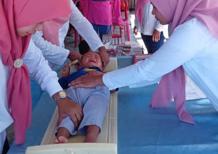 Pengukuran balita pada kegiatan Posyandu, dalam rangka pencegahan stunting dan stunted oleh Puskesmas Tilongkabila, Kabupaten Bone Bolango. Foto : Dokumentasi Puskesmas Tilongkabila.