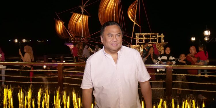 Wakil Ketua DPR RI Bidang Korinbang, Rachmat Gobel, dengan latar belakang kapal di Danau Perintis. (Foto : Dokumentasi pribadi).