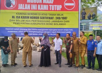 Usai musyawaha bersama Pemda, keluarga ahli waris bersama Forkopimda Bone bolango memindahkan baliho, batang pohon kelapa, dan batu yang sebelumnya membentang di jalan tersebut. Foto : Lukman/mimoza.tv