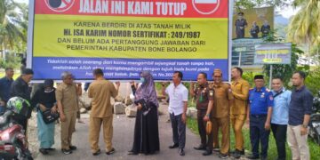 Usai musyawaha bersama Pemda, keluarga ahli waris bersama Forkopimda Bone bolango memindahkan baliho, batang pohon kelapa, dan batu yang sebelumnya membentang di jalan tersebut. Foto : Lukman/mimoza.tv