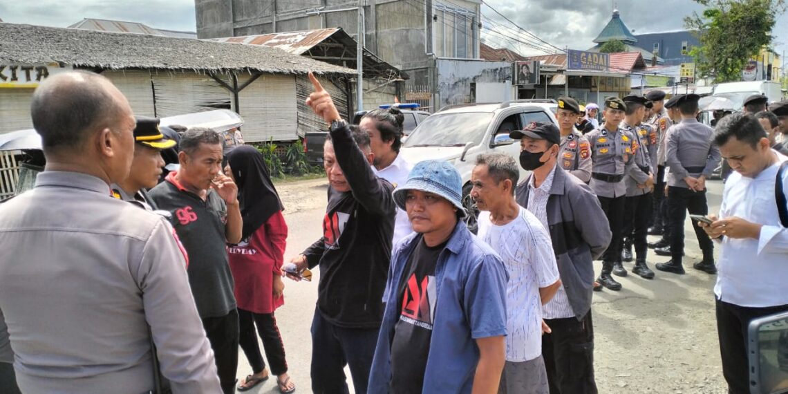 Warga di Kelurahan Tanggidaa, Kota Gorontalo yang terkena dampak proyek Kanal Banjir Tanggidaa kembali melakukan unjuk rasa di ruas Jalan HOS. Tjokroaminoto, Senin (3-6-2024). Dalam aksi itu, warga memprotes kendaraan jenis truk container yang melintas di jalan tersebut. Foto : Lukman