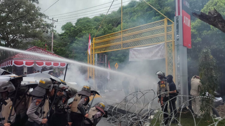 Aparat keamanan menyemprotkan air dari kendaraan water canon kepada pengunjuk rasa di Kantor DPRD Provinsi Gorontalo, Jumat (23-8-2024).