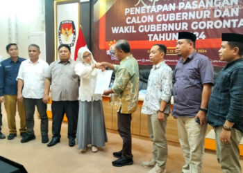 Ketua KPU Provinsi Gorontalo, Sophian Rahmola, menyerahkan surat penetapan Calon Gubernur dan Wakil Gubernur Gorontalo kepada perwakilan dari Bawaslu Provinsi Gorontalo. Foto : Lukman/mimoza.tv.