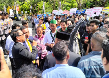 Anggota DPRD yang baru dilantik, Umar Karim (pegang mic) dan Ghalieb Lahidjun (dasi warna kuning), saat menerima massa aksi demo di depan Kantor DPRD Provinsi Gorontalo, Senin (9-9-2024). Foto : Lukman/mimoza.tv.