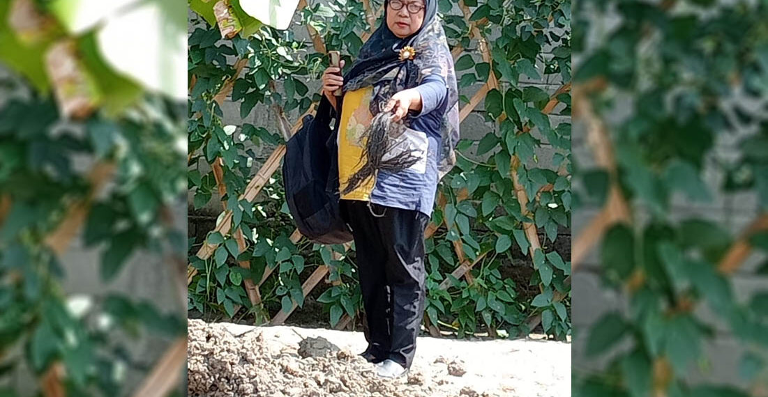 Harnida Mustapa , saat menunjukan bekas makam orang tuanya di Desa Suka Makmur, Kecamatan Tolangohula, Kabupaten Gorontalo pada Oktober 2023.