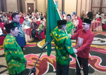 Presiden Laznah Tanfidziyah (LT) Syarikat Islam (SI), Dr. Hamdan Zoelva (kemeja merah), didampingi Wakil Presiden LT SI, Rachmat Gobel (kemeja biru), menyerahkan pataka kepada Ketua DPW SI Gorontalo, Prof. Rustam Akili. (Foto : Lukman/mimoza.tv)