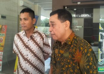 Mantan pejabat senior Pemprov Gorontalo, HH alias Husen (batik coklat) didampingi kuasa hukumnya, Ali Rajab (batik warna putih coklat).