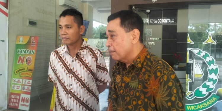 Mantan pejabat senior Pemprov Gorontalo, HH alias Husen (batik coklat) didampingi kuasa hukumnya, Ali Rajab (batik warna putih coklat).