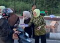 Ketua IAD Wilayah Kejari Bone Bolango, Dina Feddy Hantyo, saat membagikan takjil kepada pengendara yang melintas di kompleks tugu Center Point.