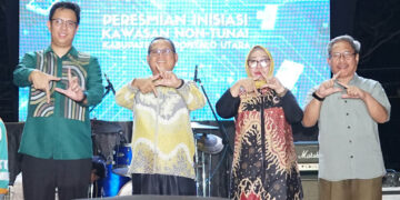 Kepala Perwakilan Bank Indonesia Provinsi Gorontalo bersama jajaran Pemerintah Kabupaten Gorontalo Utara berpose menunjukkan simbol digitalisasi pada peresmian Kawasan Non-Tunai di Blok Plan, (26/04).