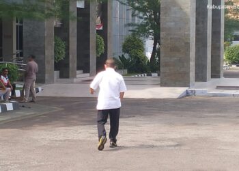 Ketua KONI Provinsi Gorontalo, Fikram Salilama, saat menuju ruang pemeriksaan intensif oleh penyidik Kejaksaan Tinggi (Kejati) Gorontalo, Jumat (10/4/2025). Foto Lukman.