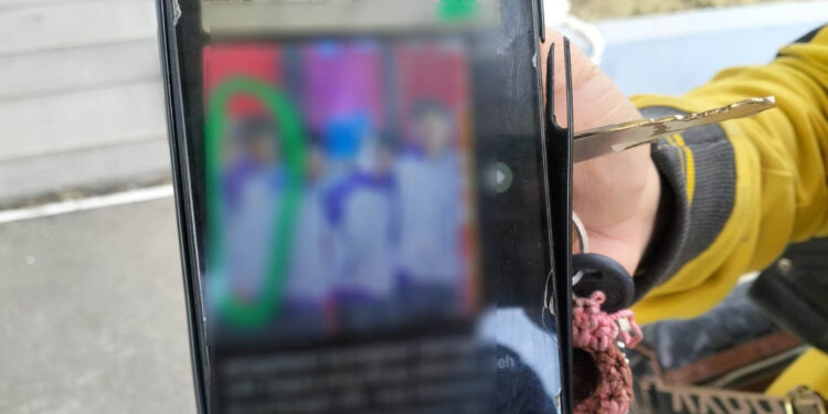 Seorang saksi memperlihatkan dokumentasi dalam ponselnya kepada wartawan usai menjalani pemeriksaan di Kejati Gorontalo, Senin (20/4/2026). Foto tersebut diklaim berkaitan dengan perlakuan terhadap atlet e-sport. (Gambar dalam layar telah disamarkan).