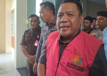 Tersangka STA saat keluar dari Gedung Kejaksaan Negeri Kabupaten Gorontalo mengenakan rompi tahanan, Senin (27/4/2026). STA, mantan Ketua DPRD Kabupaten Gorontalo, ditahan terkait dugaan korupsi Dana Tunjangan Komunikasi Intensif (TKI) periode 2022–2023 yang merugikan negara sekitar Rp3 miliar. (Foto: Andre, untuk mimoza.tv)