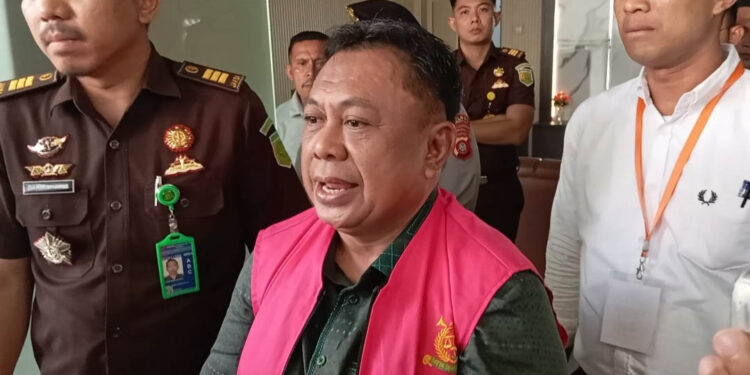HRA, mantan anggota DPRD Kabupaten Gorontalo, mengenakan rompi tahanan saat digiring usai pemeriksaan di Kejari Kabupaten Gorontalo, Senin (4/5/2026). Ia ditetapkan sebagai tersangka dalam kasus dugaan korupsi tunjangan komunikasi intensif (TKI) tahun anggaran 2022–2023, menyusul penahanan mantan Ketua DPRD sebelumnya. Penyidik memastikan, pengusutan perkara masih terus dikembangkan untuk menelusuri kemungkinan keterlibatan pihak lain.