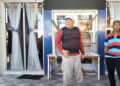 Benny Lengkey (tengah) berdiri di depan pintu Kantor Desa Toto Utara yang telah disegel dalam aksi protes terhadap keputusan pemberhentian sementara Kepala Desa Toto Utara, Ramlah Djafar. Penyegelan mengakibatkan aktivitas di kantor desa terhenti, sementara aparat TNI dan Polri berjaga di lokasi untuk mengamankan situasi.