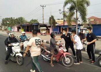 Kepala Kejari Bone Bolango, Feddy Hantyo Nugroho, S.H., M.H., bersama jajaran dan Ikatan Adhyaksa Dharmakarini (IAD) saat membagikan masker kepada pengendara di kawasan Center Point Bone Bolango, Jumat (16/10). Foto: Lukman.
