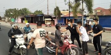 Kepala Kejari Bone Bolango, Feddy Hantyo Nugroho, S.H., M.H., bersama jajaran dan Ikatan Adhyaksa Dharmakarini (IAD) saat membagikan masker kepada pengendara di kawasan Center Point Bone Bolango, Jumat (16/10). Foto: Lukman.