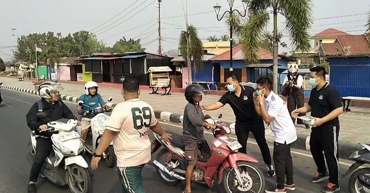 Kepala Kejari Bone Bolango, Feddy Hantyo Nugroho, S.H., M.H., bersama jajaran dan Ikatan Adhyaksa Dharmakarini (IAD) saat membagikan masker kepada pengendara di kawasan Center Point Bone Bolango, Jumat (16/10). Foto: Lukman.